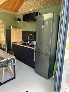 a kitchen with a stainless steel refrigerator in a room at La Ruche Enchantée in Champigny-sur-Veude