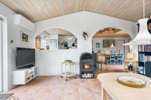 a living room with a fireplace and a tv at 10732-Ulfborg-Svollingvej-94 in Ulfborg
