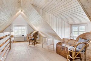 a attic room with chairs and a wooden ceiling at 10732-Ulfborg-Svollingvej-94 in Ulfborg