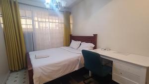 KikuyuHighway Studio Kinoo的一间卧室配有一张带书桌和一张书桌的床。