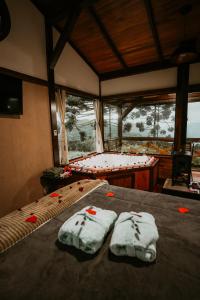Dos camas en una habitación con rosas rojas. en Sítio Mar de Nuvens Chalés Morro da Igreja, Urubici, SC., en Urubici 218 fotos más
