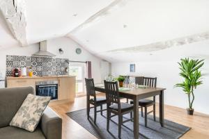 une cuisine et un salon avec une table et des chaises dans l'établissement Appartement sous combles - vieille batisse proche centre ville, à Saint-Galmier