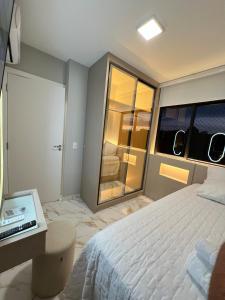 a bedroom with a bed and a laptop on a desk at Apto compacto, novo e moderno in Foz do Iguaçu