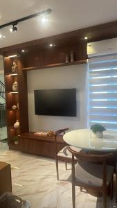 a living room with a tv and a table at Apto compacto, novo e moderno in Foz do Iguaçu +5 photos