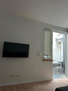 ein Wohnzimmer mit einem Flachbildfernseher an der Wand in der Unterkunft Rheingoldnest in Boppard