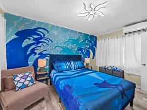 a bedroom with a blue bed and a chair at Spacious Unique Heated Pool 2 Hot Tubs Pkg in Sarasota +81 photos
