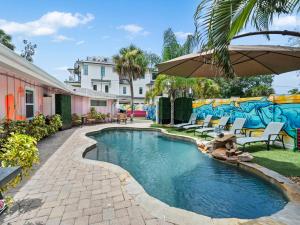 a swimming pool with an umbrella in a yard at Spacious Unique Heated Pool 2 Hot Tubs Pkg in Sarasota