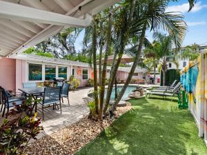 a patio with a table and chairs and a palm tree at Spacious Unique Heated Pool 2 Hot Tubs Pkg in Sarasota
