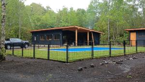 una casa con piscina delante de ella en Cabaña pilina, en Pucón