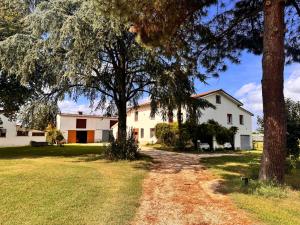 a house with trees and a dirt road at B&B Orto di Borghi in Faenza