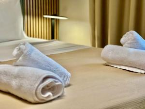 two towels sitting on top of a bed at Douloudis Luxury Apartment in Alexandroupoli