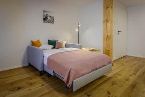 a bedroom with a bed and a wooden floor at am Egg in Rettenberg