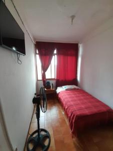 a bedroom with a red bed and a window at El Paraiso in Puerto Ayora