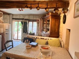 a kitchen with a table with a bowl of soup on it at Abbaye Cottage - Maison entière - jardin - jacuzzi in Fontevraud-l'Abbaye