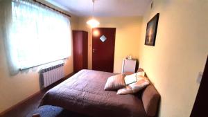 een slaapkamer met een bed met een groot raam bij ŁÓDZKI DOM TURYSTYCZNY ŁÓDŹ-Helenówek,Pokoje z łazienkami,F-VAT,Parking gratis tylko auta osobowe in Łódź