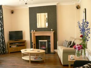 a living room with a couch and a fireplace at Ashberry Guest House in Penrith