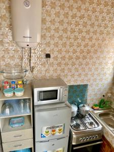 eine kleine Küche mit einer Mikrowelle auf dem Kühlschrank in der Unterkunft Résidences Lysette 3 in Bouaké + 4 Fotos