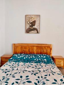 ein Schlafzimmer mit einem Bett und einem Bild an der Wand in der Unterkunft Résidences Lysette 3 in Bouaké