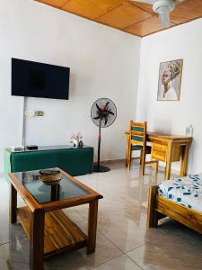 ein Wohnzimmer mit einem Sofa, einem Tisch und einem Ventilator in der Unterkunft Résidences Lysette 3 in Bouaké