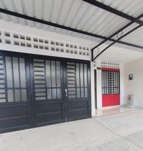 a garage with black doors and a red door at Casa del Sol in Mariquita