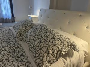 ein Bett mit einer schwarzen und weißen Bettdecke und Kissen in der Unterkunft Cinema Rooms Fiera Verona in Verona