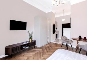 una sala de estar con un televisor y una mesa en SOHO by VAYA STAYS, en Varsovia