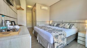 a hotel room with a large bed and a sink at Hotel Glamour da Serra in Gramado