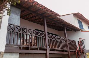 a balcony of a house with a wooden railing at Casa em Búzios com vista espetacular in Búzios