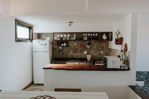 a kitchen with a counter and a refrigerator at Casa em Búzios com vista espetacular in Búzios