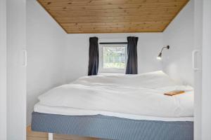 sypialnia z białym łóżkiem i oknem w obiekcie 40798-Ulfborg-Helmklit-324 w mieście Fjand Gårde