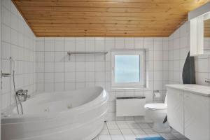 biała łazienka z wanną i toaletą w obiekcie 40798-Ulfborg-Helmklit-324 w mieście Fjand Gårde +18 zdjęć
