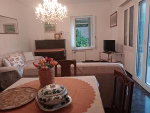 a living room with a table with a vase of flowers on it at Roses House in Sestri Levante
