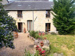 a stone house with a garden in front of it at Abbaye Cottage - Maison entière - jardin - jacuzzi in Fontevraud-l'Abbaye