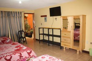 a bedroom with a bed and a tv on the wall at Hotel Kasa Kamelot in Quetzaltenango