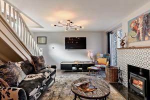 un salon avec un canapé et une cheminée dans l'établissement Victoria Cottage - Wensum Retreats, à Gunthorpe