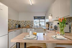 une cuisine avec une table en bois et un vase de fleurs dans l'établissement Victoria Cottage - Wensum Retreats, à Gunthorpe