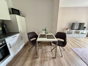 a small kitchen with a table and two chairs at Ferienwohnung Bertchen - barrierefrei mit Südterrasse und Carport in ruhiger Altstadtlage von Ballenstedt in Ballenstedt