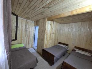 a room with two beds in a wooden room at Poli in Ushguli +13 photos
