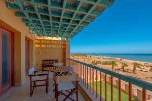 a balcony with tables and chairs and a view of the beach at Luxury Stays in New Marina, El Gouna in Hurghada