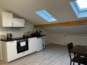 a kitchen with white appliances and a table in a room at CityStay Bergisch Gladbach in Bergisch Gladbach