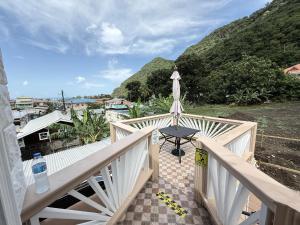 a balcony with a table and a view of a mountain at Maggie's Inn in Soufrière