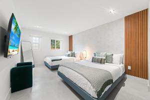 a bedroom with two beds and a flat screen tv at Family Fun Haven Pool, Mini Golf and More L78 in Miami +49 photos