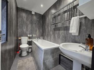 a bathroom with a sink and a tub and a toilet at Room 1 shared house 5 minutes from Anfield in Liverpool