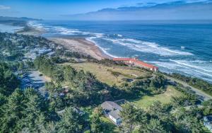 an aerial view of a house on a hill next to the ocean at The Pacific Lookout Sleeps 6, Hot Tub, Pet Friendly, Ocean View, EV Charger in Salishan Beach