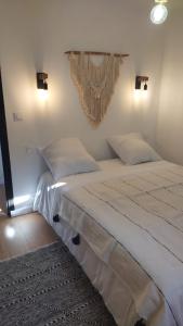 Un dormitorio con una gran cama blanca con dos almohadas. en Catalunya, en Font-Romeu-Odeillo-Via