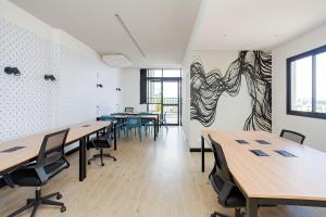 a room with tables and chairs and a painting on the wall at Estúdio Moderno e Completo no Coração de Curitiba in Curitiba +26 photos