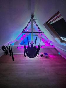un hélicoptère suspendu à un plafond avec des lumières roses dans l'établissement La Maison Du Plaisir Loveroom Pontorson, à Pontorson 5 autres photos
