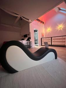 Cette chambre comprend un lit avec un ordinateur portable. dans l'établissement La Maison Du Plaisir Loveroom Pontorson, à Pontorson