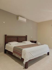 a bedroom with a bed and a air conditioner at HOTEL VILLA CALAKMUL in Xpujil