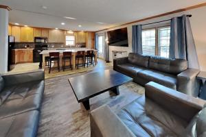 a living room with a leather couch and a table at Island Club #111 in Put-in-Bay